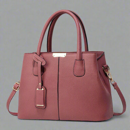 Pink handbag with gold accents on a white background